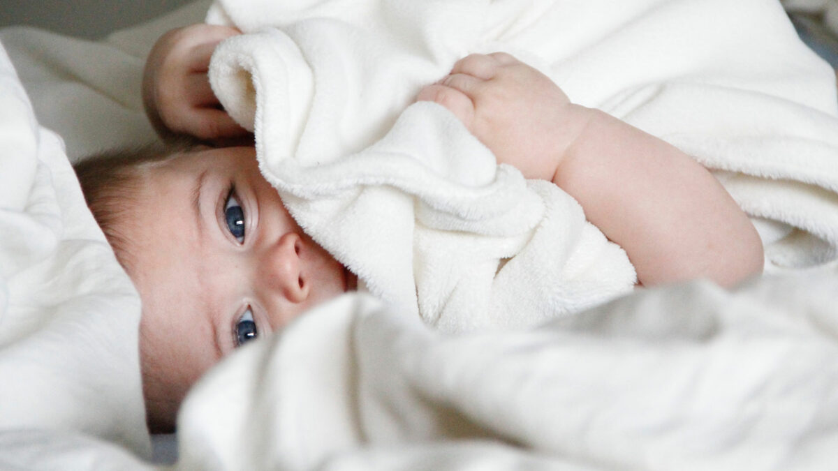 Über das Leben mit Babys: Baby entspannt eingekuschelt im Bett // HIMBEER