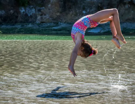 Kindersport: Mädchen Salto Im Wasser / Himbeer