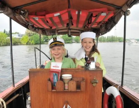 Zwei Kinder Hinterm Steuerrad Auf Dem Boot Auf Der Spree // Himbeer